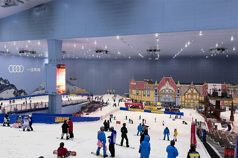 A group of snowboarders making their way down a slope at the indoor Guangzhou Sunac Snow Park.